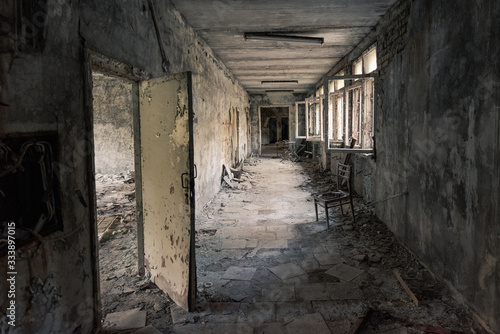 Hallway with open windows in abandoned school in Pripyat near Chernobyl in Ukraine