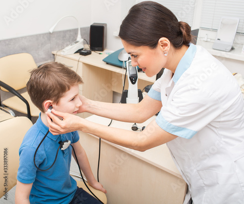 Audiologist woman is doing a hearing exam on a boy. Impedance audiometry. Methods for testing the middle ear in a child