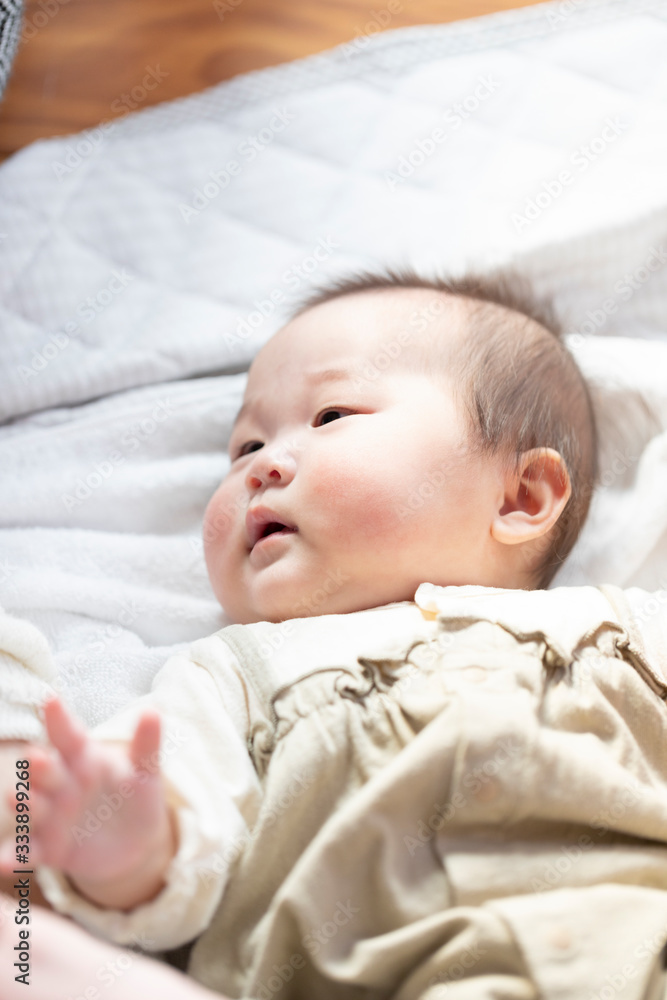 明るい部屋の中で仰向けになるかわいい赤ちゃん 明るい部屋の中で仰向けになるかわいい赤ちゃん