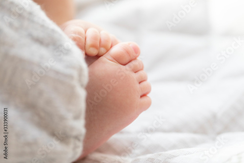 明るい部屋の中で寝転ぶ赤ちゃんの足