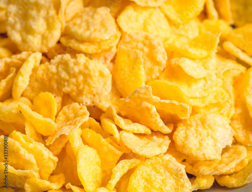 Tasty crispy corn flakes in bowl on the rustic background. Selective focus. Shallow depth of field.