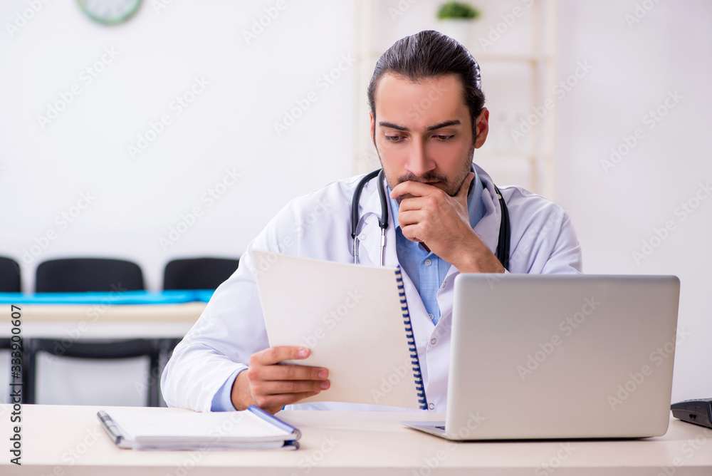 Young handsome male doctor working in the clinic Young handsome male doctor working in the clinic