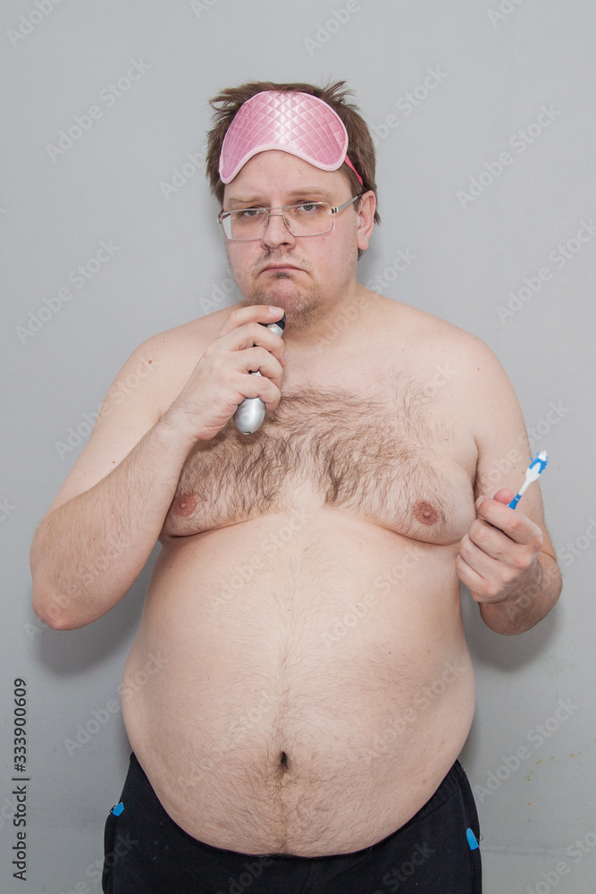 A fat man with a beer belly woke up in the morning. Morning Ritual: Brushing Teeth and Shaving A fat man with a beer belly woke up in the morning. Morning Ritual: Brushing Teeth and Shaving