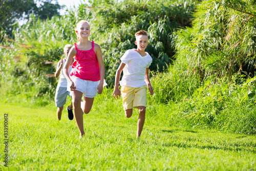 Group of laughing children having fun together outdoors running