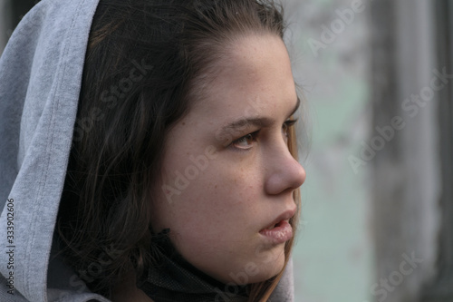 Young beautiful woman looking into the distance on the background of an abandoned building. Female portrait. Beauty Woman Portrait Teen Girl. Girl with freckles.