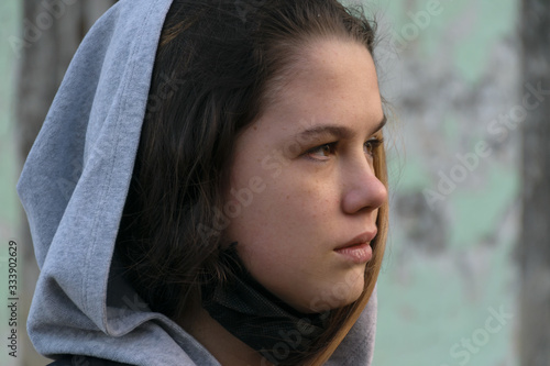 Young beautiful woman looking into the distance on the background of an abandoned building. Female portrait. Beauty Woman Portrait Teen Girl. Girl with freckles.