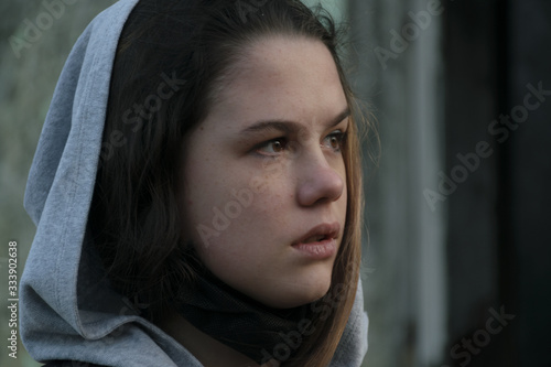 Young beautiful woman looking into the distance on the background of an abandoned building. Female portrait. Beauty Woman Portrait Teen Girl. Girl with freckles.