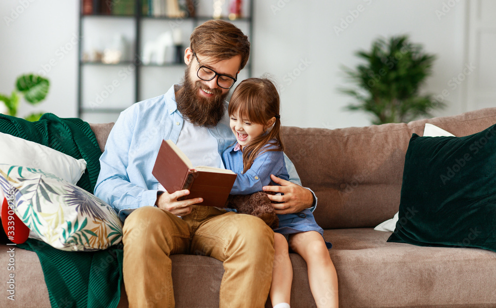 happy family. father reads a book to a child   at home   .