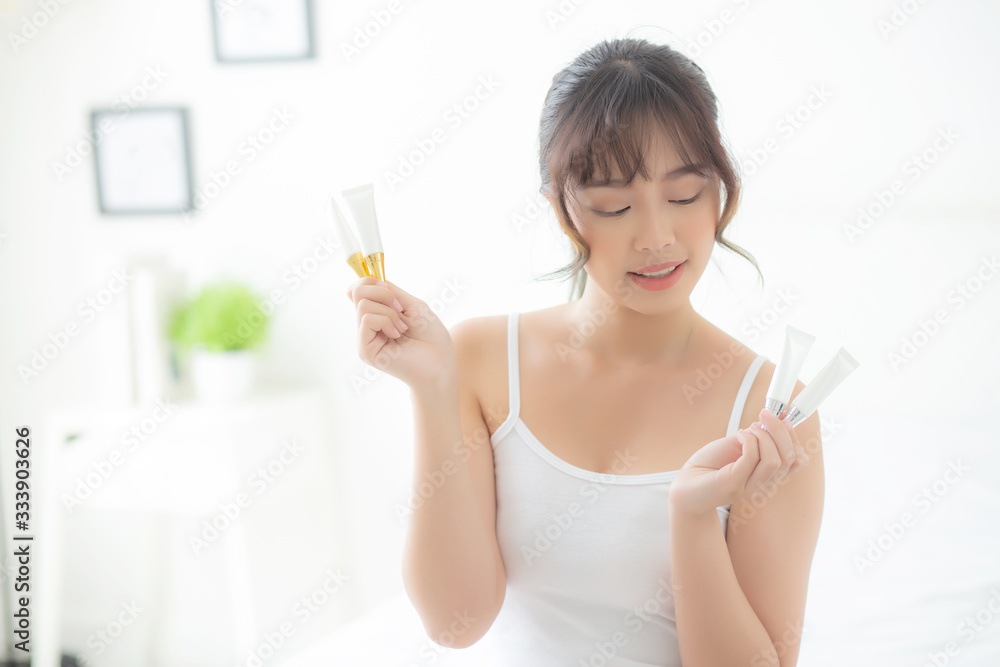 Beautiful portrait young asian woman holding and presenting cream or lotion product, beauty asia girl show cosmetic makeup and moisturizing for skin care, healthy care and wellness concept. Beautiful portrait young asian woman holding and presenting cream or lotion product, beauty asia girl show cosmetic makeup and moisturizing for skin care, healthy care and wellness concept.