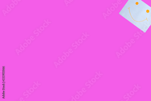 Paper with a smiling face on a pink background