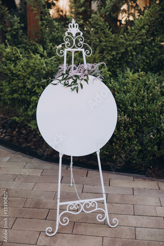 a white party board stands in the backyard garden and is decorated with flowers