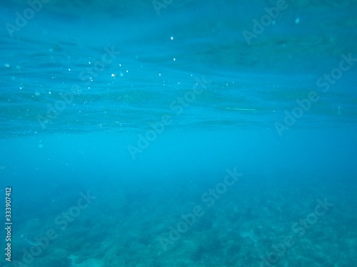 Rocky sea floor with reflections of sunlight .