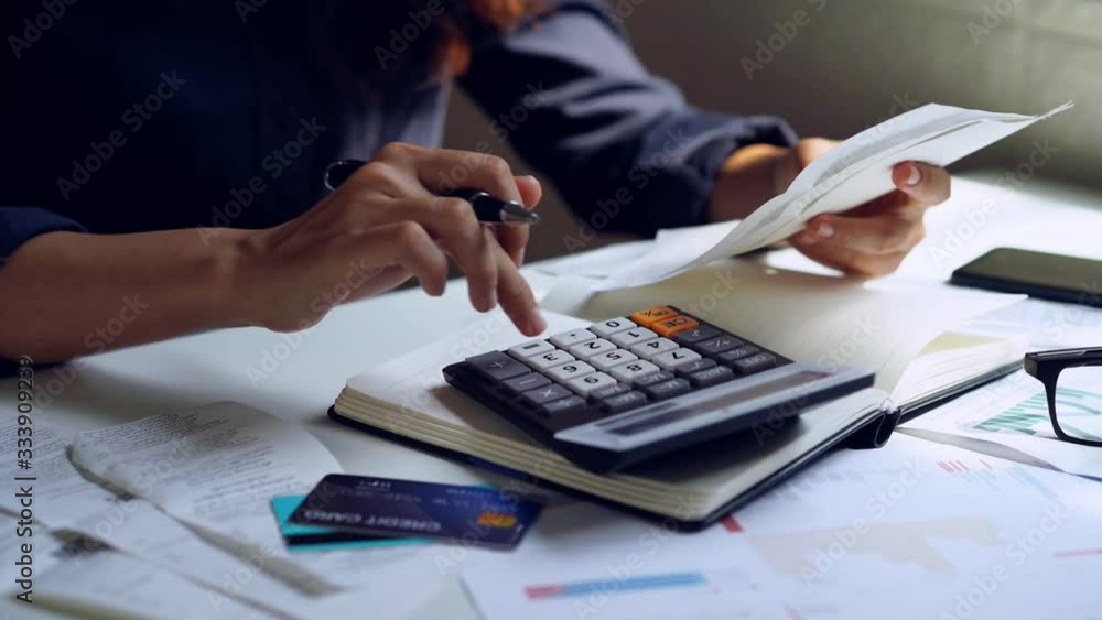 Stressed young woman checking bills, taxes, bank account balance and calculating expenses in the living room at home