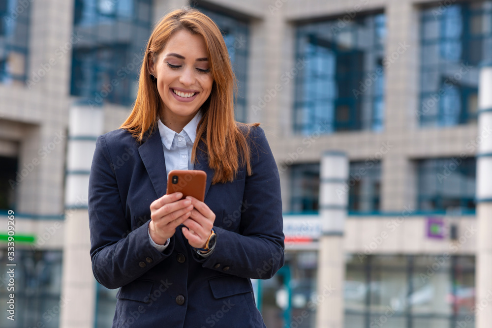 Young business woman holding phone and sending a text Young business woman holding phone and sending a text