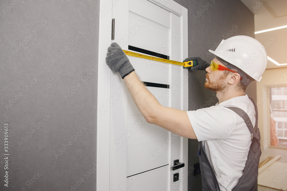 Carpenter worker installation process of measures cloth with ruler door hinge Carpenter worker installation process of measures cloth with ruler door hinge