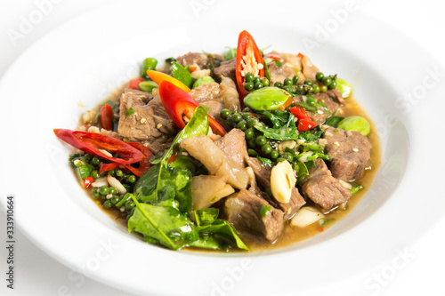 spicy stir fired beef oyster sauce with pepper seeds kaffir lime leaves sato and paprika chili serve on white plate