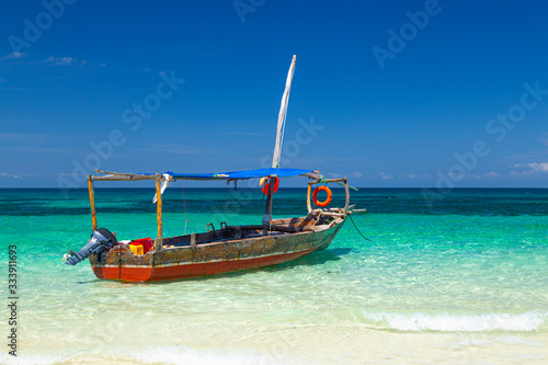 Old colorful african wooden boat on  ocean surface © anatoliil