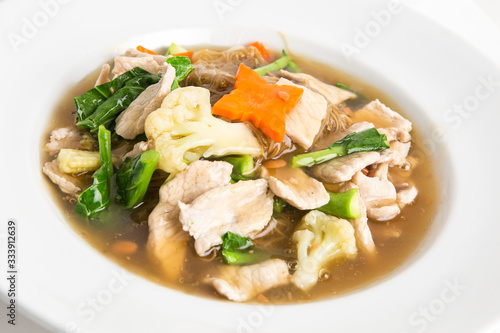 fried noodles with pork  kale and cauliflower in gravy soy sauce decorate with carrots and baby corn closeup shot serve in white dish chinese food asian style