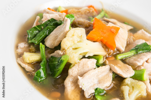 fried noodles with pork kale and cauliflower in gravy soy sauce decorate with carrots and baby corn closeup shot serve in white dish chinese food asian style