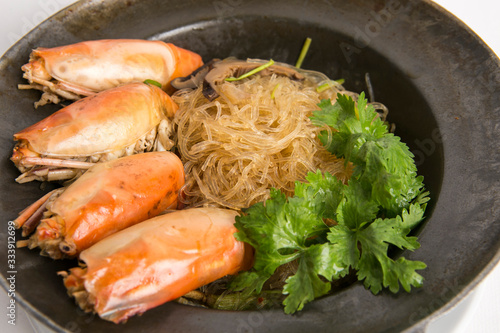 casseroled prawns with glass noodles top with shitake mushrooms and coriander serve in black pot