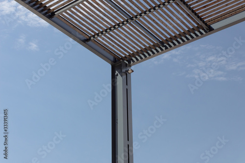 Modern urban architectural construction of metal and wood for sun shade, horizontal aspect