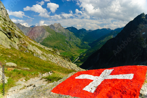 Swiss flag with Val Ferret valley and Great Saint Bernard Pass in Switzerland