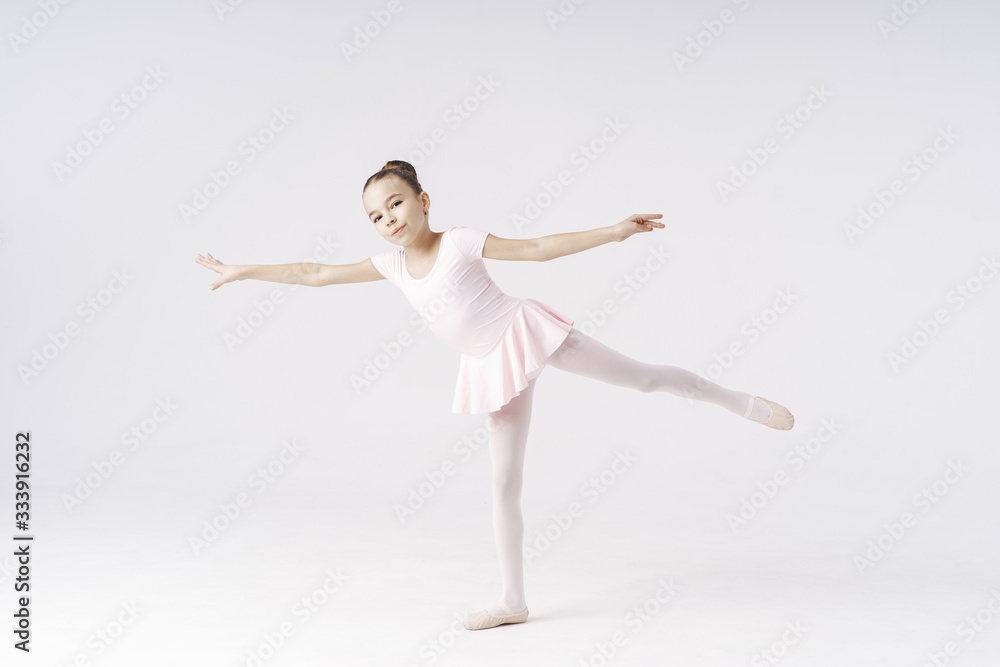 Fototapeta premium Adorable pre-teen ballerina dancing on white background