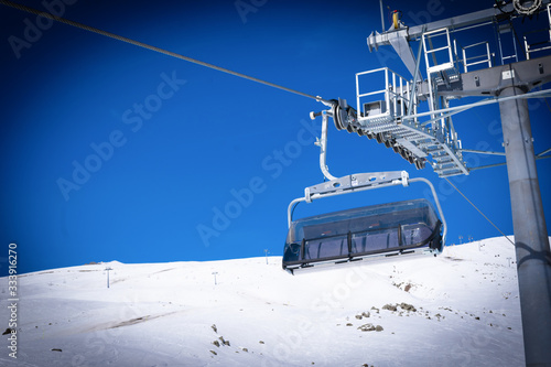 Empty chair lift and holding contructions with snowy peak in the background. Ski resort end season 2020. Gudauri. Georgia photo