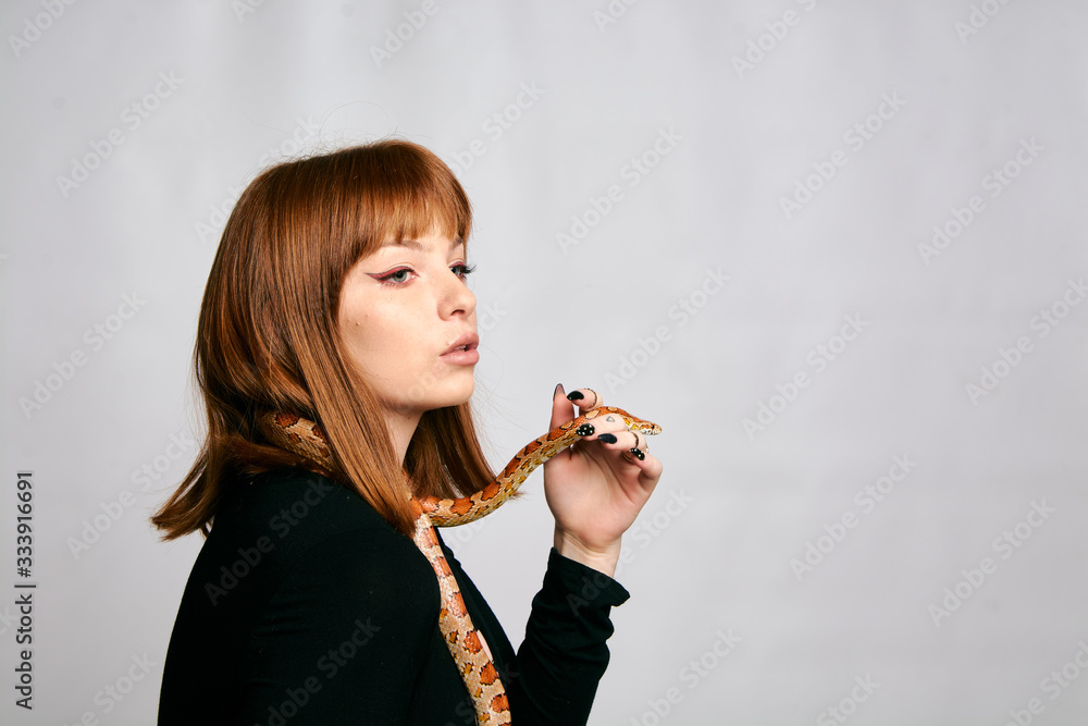 Beautiful woman in black bodywear and snake. Ginger model girl with fashion perfect make up. Beautiful woman in black bodywear and snake. Ginger model girl with fashion perfect make up.