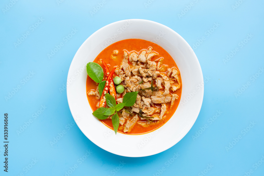 Panaeng Curry with pork in white bowl on blue background. Copy space Panaeng Curry with pork in white bowl on blue background. Copy space