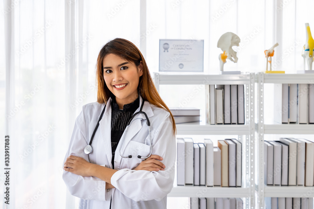 Portrait of a smiling attractive Asian medical doctor wheelchair in examination room in clinic hospital, looking at camera Portrait of a smiling attractive Asian medical doctor wheelchair in examination room in clinic hospital, looking at camera