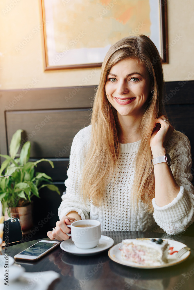 girl in a cafe in the hands of a smartphone