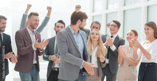 cheerful employees congratulating a colleague on the promotion