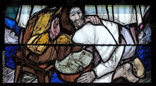 God begins salvation in this world through His Son Jesus Christ, detail of stained glass window by Sieger Koder in St. John church in Piflas, Germany photo