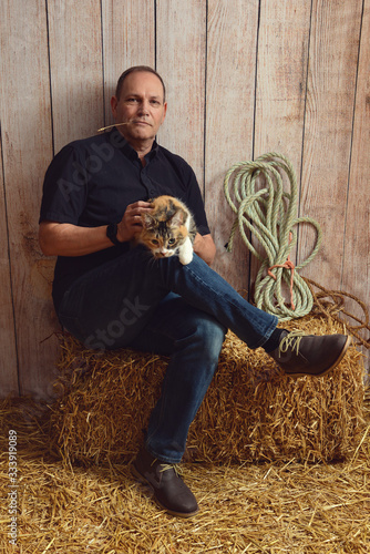 man playing with cat in a barn © Michael Gray