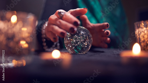 Fortuneteller woman's hands with predictions ball photo
