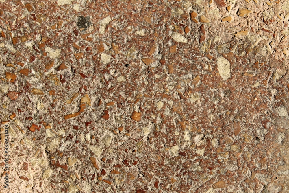 Reddish conglomerate rock grains texture on a rough surface Reddish conglomerate rock grains texture on a rough surface