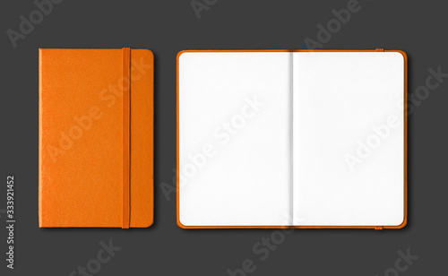 Orange closed and open notebooks isolated on black