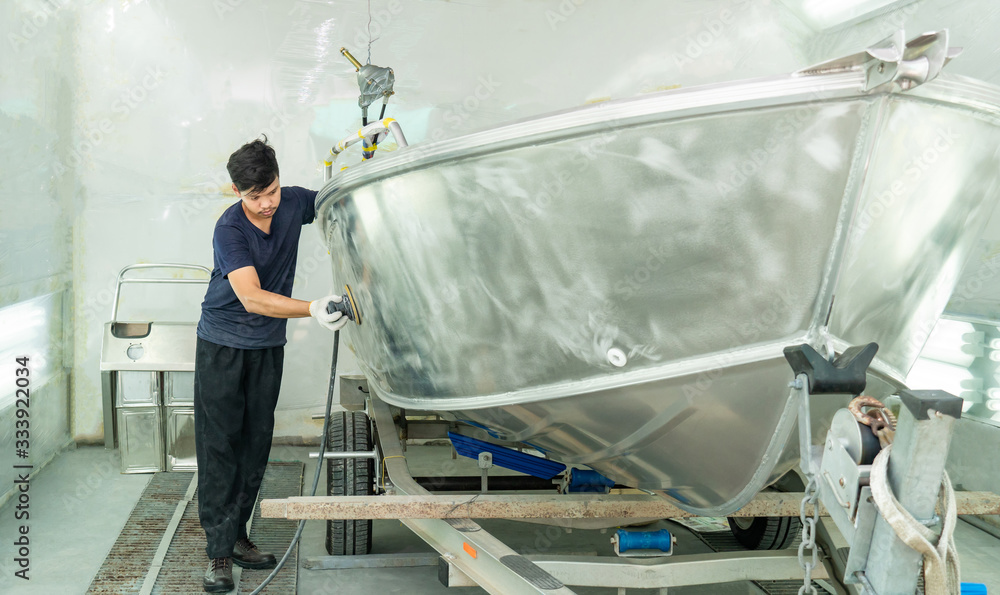 Aluminum boat painting procedure at service center ,The mechanic is using a metal grinder. , Surface preparation, boat body, for spray painting ship