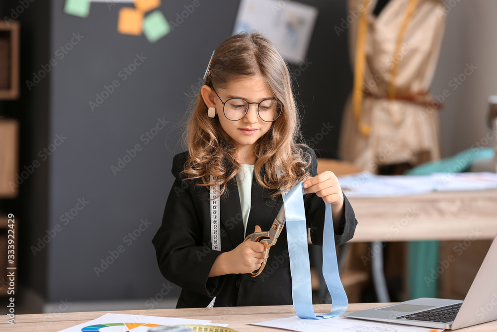 Cute little dressmaker working in atelier Cute little dressmaker working in atelier