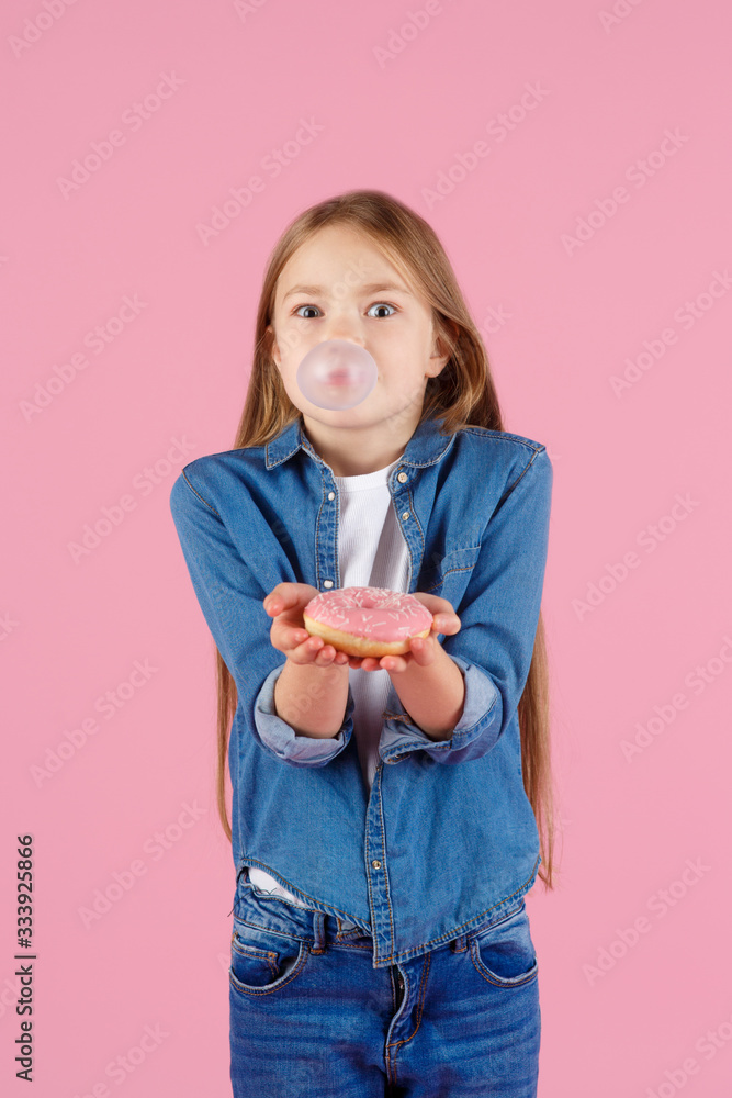 Little girl with sun glasses blowing up pink chewing gum against a light purple background Little girl with sun glasses blowing up pink chewing gum against a light purple background