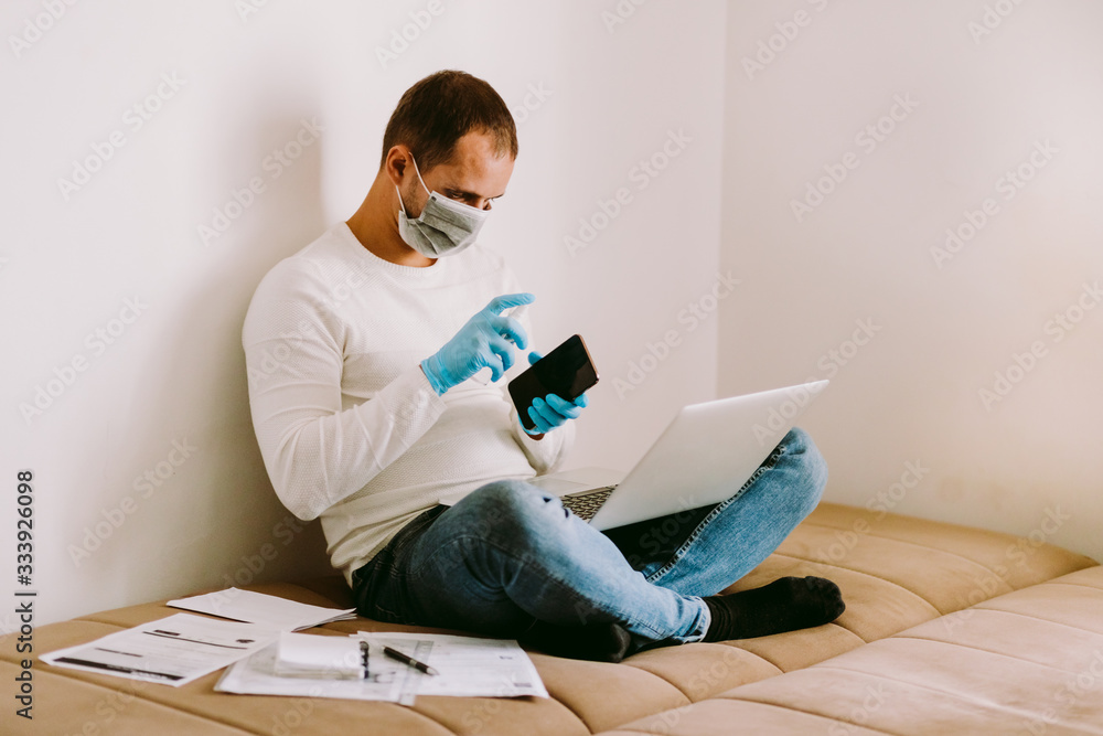 Obraz premium man with laptop and smartphone during quarantine at home