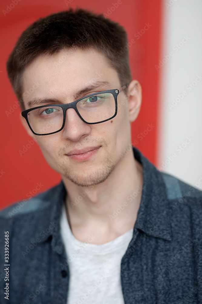 portrait of a cute guy with very bright facial expressions and emotions against a red wall portrait of a cute guy with very bright facial expressions and emotions against a red wall
