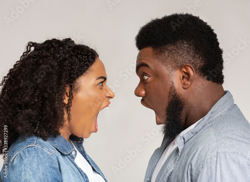 Relationship problems. Profile portrait of angry black couple arguing photo