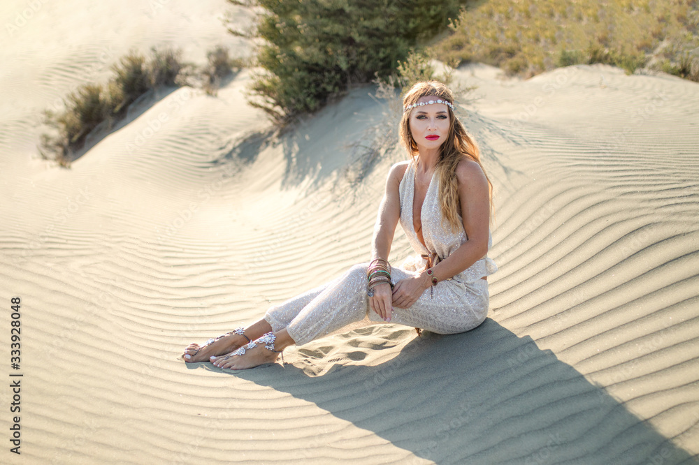 Beautiful caucasian female model dressed in oriental closes, belly dancer like, outdoor in a desert Beautiful caucasian female model dressed in oriental closes, belly dancer like, outdoor in a desert