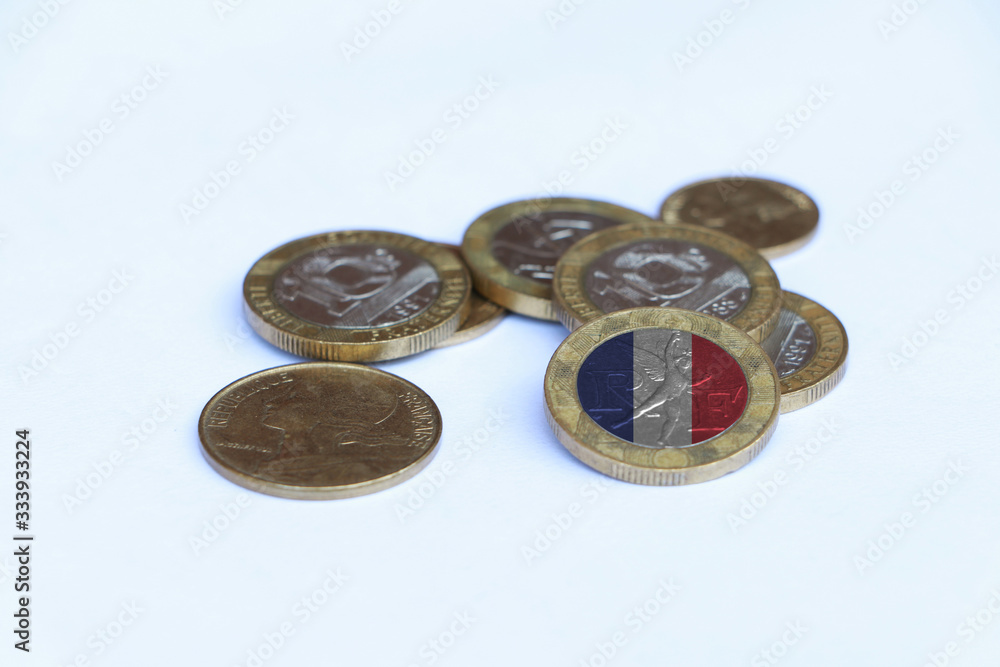 France flag on the coin with heap of  French franc money on the white background. Concept of finance.