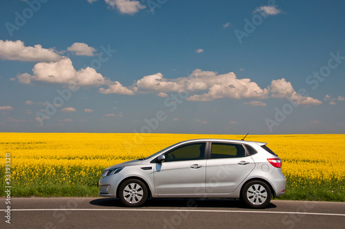 KIEV, UKRAINE-JULY 4, 2016: Kia Rio parked on the road near the field.  Automotive photography. Space for text. Nature background with car. Landscape with car. Spring field and car. photo