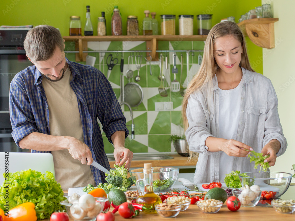 Millennial couple preparing healthy vegetarian salad enjoying process