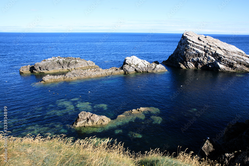 Portknockie (Scotland), UK - August 01, 2018: Coastal landscape at Bow Fiddle Rock sea arch, Portknockie, Scotland, Highlands, United Kingdom Portknockie (Scotland), UK - August 01, 2018: Coastal landscape at Bow Fiddle Rock sea arch, Portknockie, Scotland, Highlands, United Kingdom