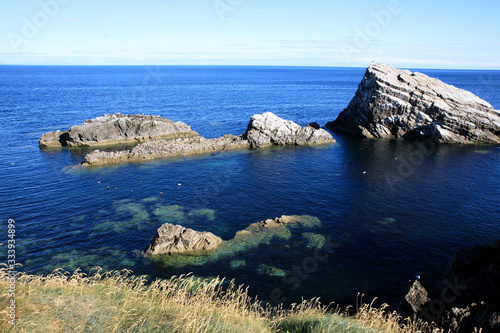 Portknockie (Scotland), UK - August 01, 2018: Coastal landscape at Bow Fiddle Rock sea arch, Portknockie, Scotland, Highlands, United Kingdom